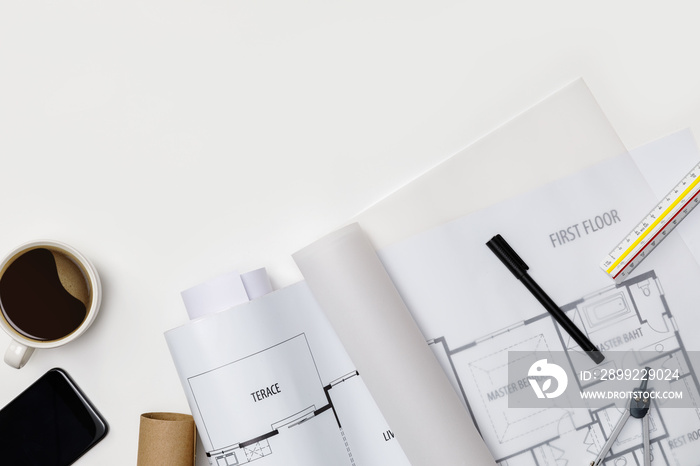 Creative flat lay of architects white table with roll blueprints, architectural project plan, engineering tools, office supplies and a cup of hot coffee,Workspace for designer concept