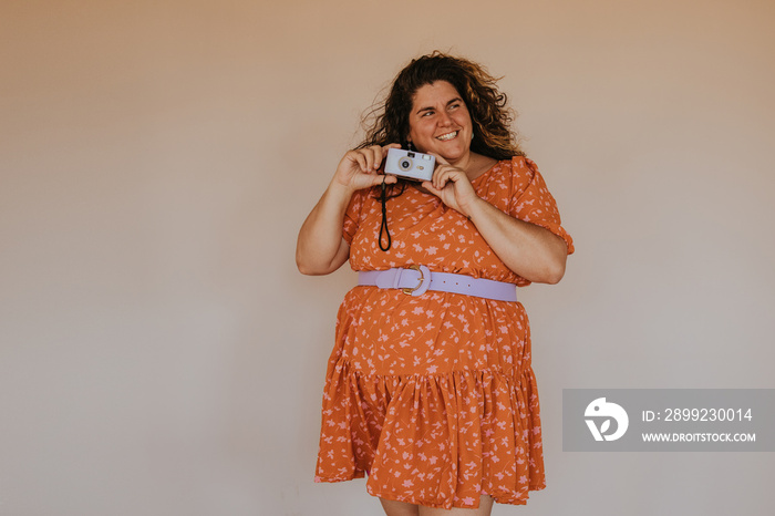 pluls size person holding camera wearing dress