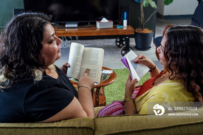 Two friends having a discussion over what books they are reading