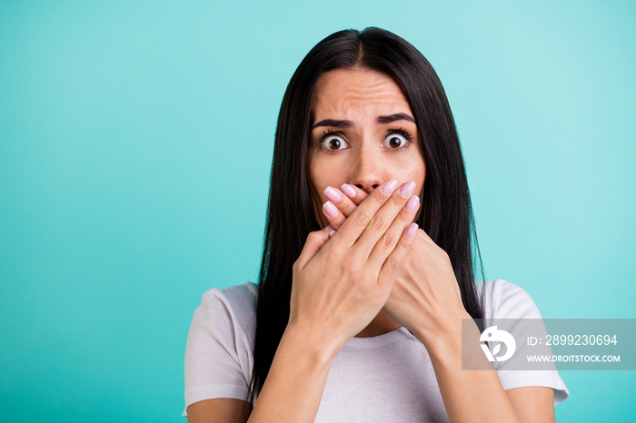 Close up portrait of crazy mad woman feeling guilty about telling secret information covering her mouth with hands isolated with negative emotions teal color vibrant background