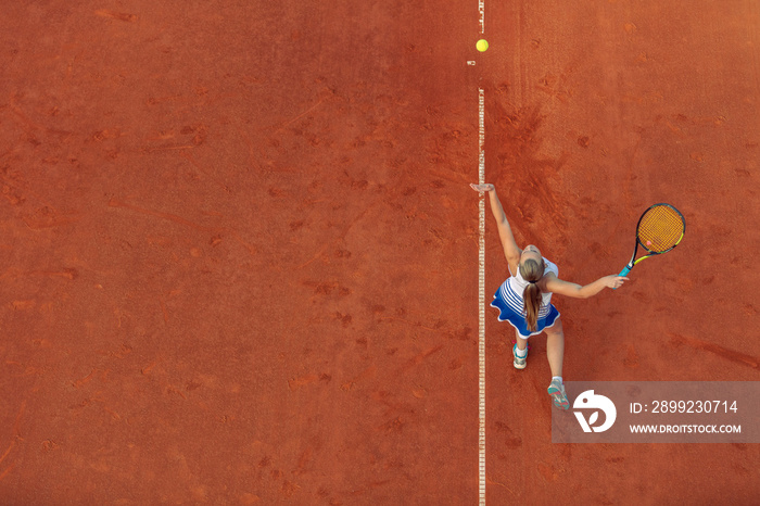 Aerial shot of a female tennis player on a court during match. Young woman playing tennis.High angle view.