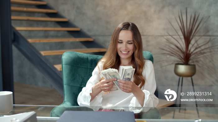 Happy woman throwing bundle of money away. Business woman counting money.