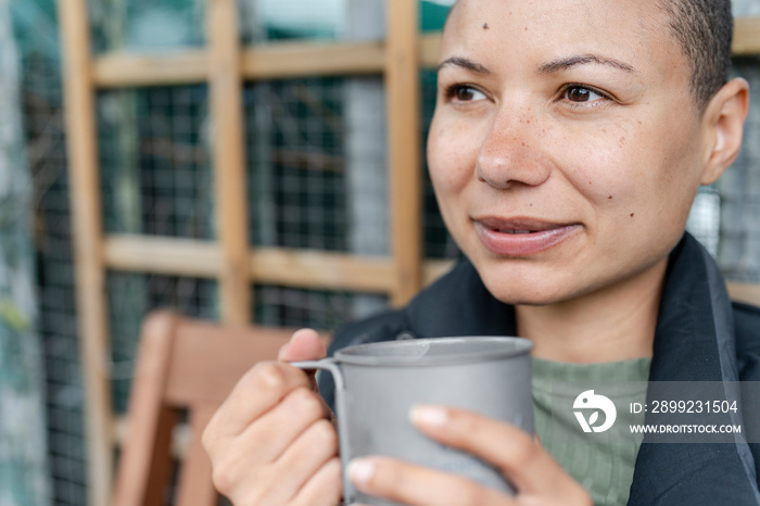 Close-up of woman holding metal mug in urban garden