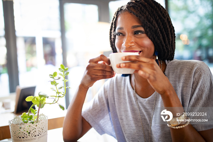 Beautiful young african woman enjoying a cup of coffee