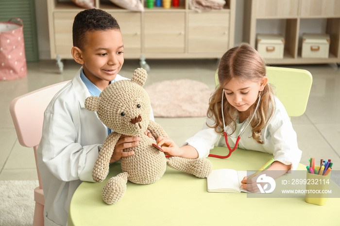 Cute little children dressed as doctors playing at home