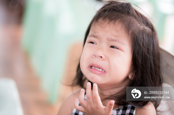 Head shot of Asian cute girl is crying self-indulgent for some dissatisfaction.Kid looks at camera. Terrible two concept.