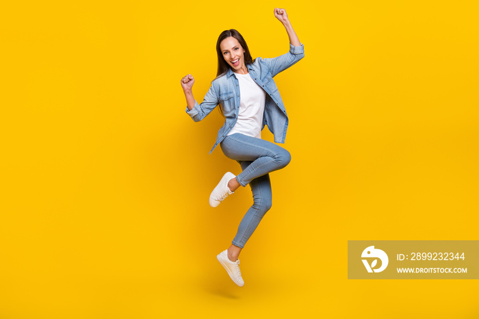 Full body photo of young optimistic lady yell jump wear jeans shirt shoes isolated on yellow color background