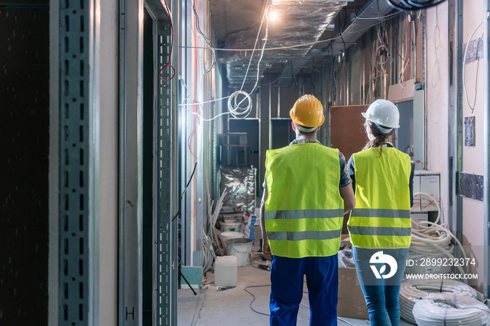 Builder and construction worker inspecting the site