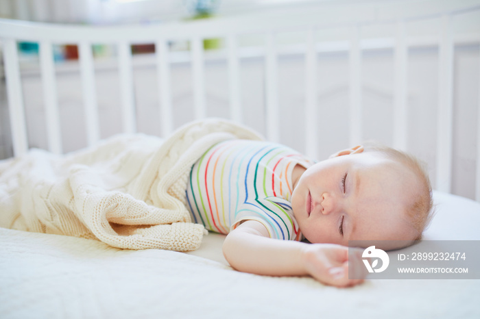 Baby girl sleeping in co-sleeper crib