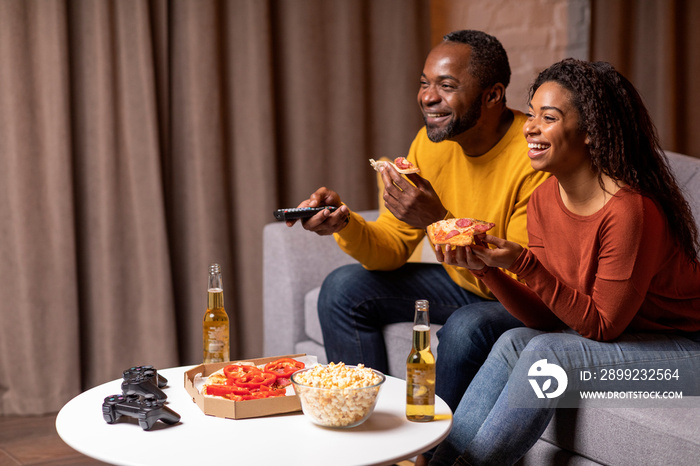 Side view of black spouses watching movie or TV show