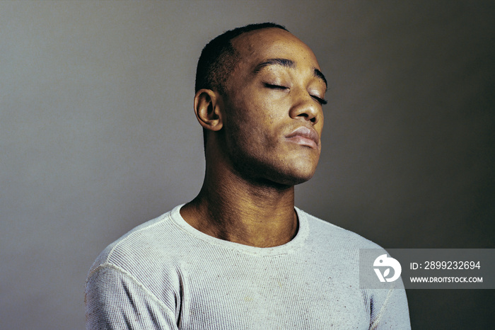 Studio closeup profile of meditating black man with eyes closed