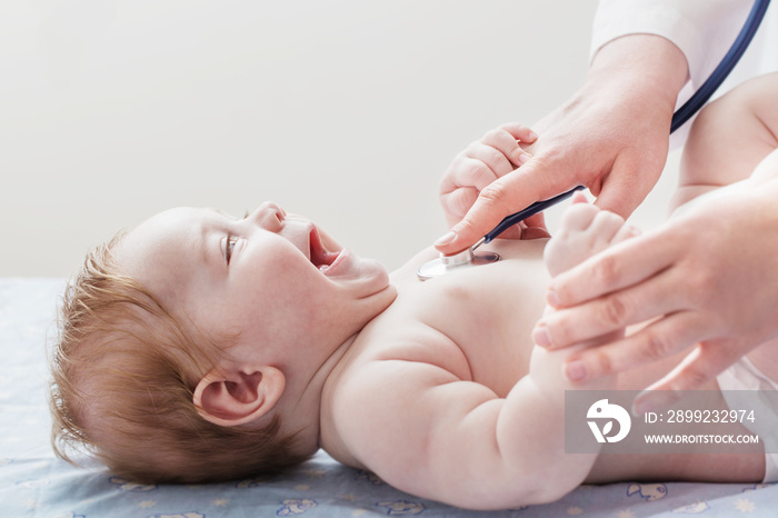 doctor listens to small child with  stethoscope