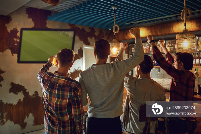 A group of friends watching tv football in a sports bar.