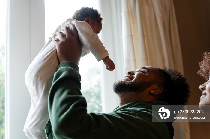 Mother looking at father holding baby daughter