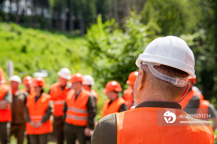 Engineer team in hardhat for work. Worker group wearing vest, safety. Building concept. Architector, engineers on constructing site. Builder man. Helmet builder. Many construction workers helmet