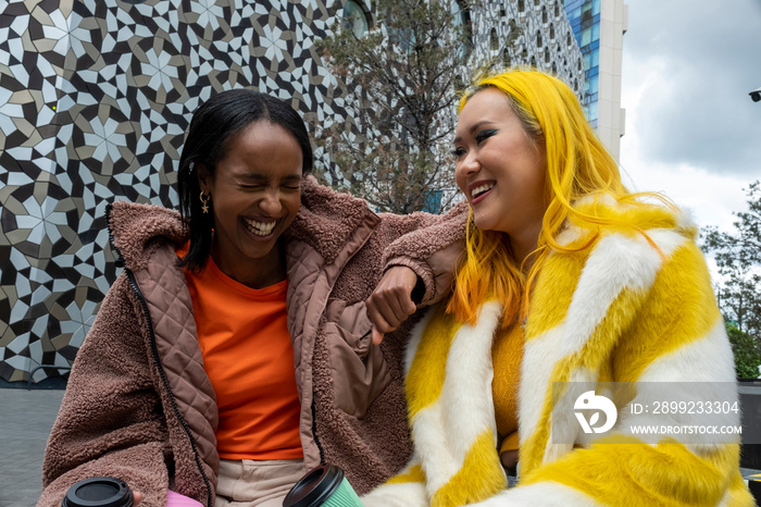 Young female friends laughing outdoors