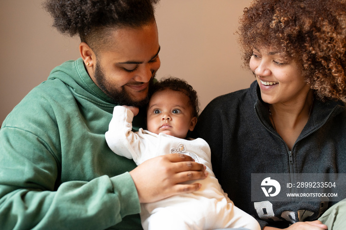 Parents sitting with baby daughter at home