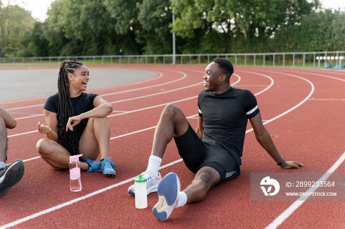 Group of athletes resting at sports track after training