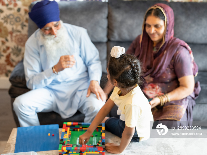 Grandparents and grandson (6-7) playing with toy blocks