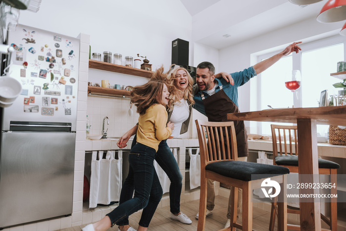 Parents having fun with their cute daughter at home