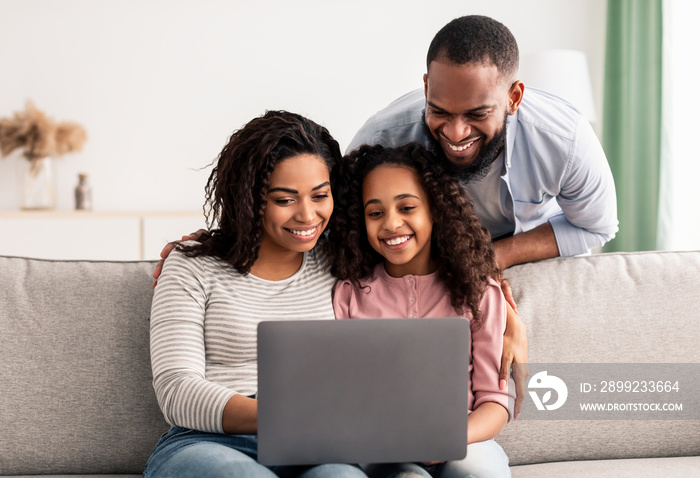 Happy african american family using laptop in living room