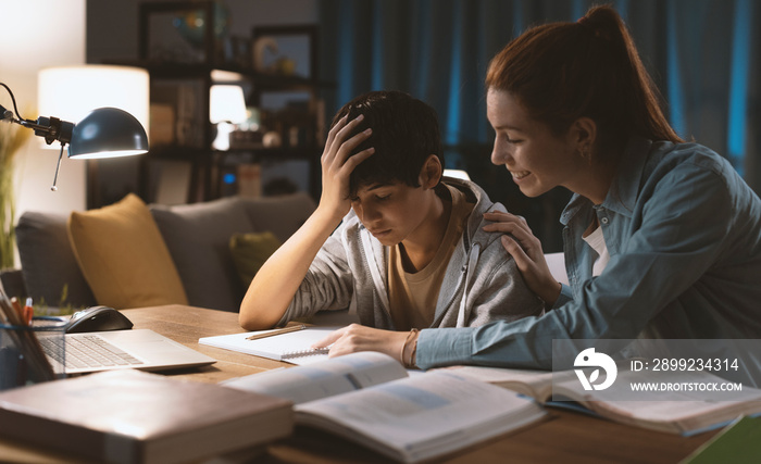 Sister helping her younger brother with his homework