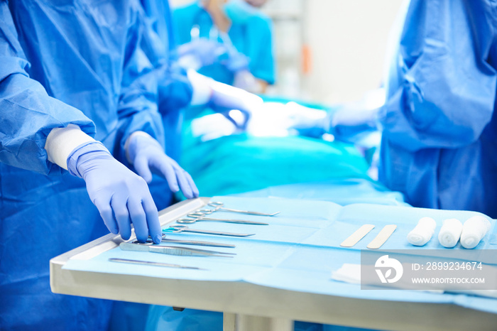 Surgeon taking scissors from the table