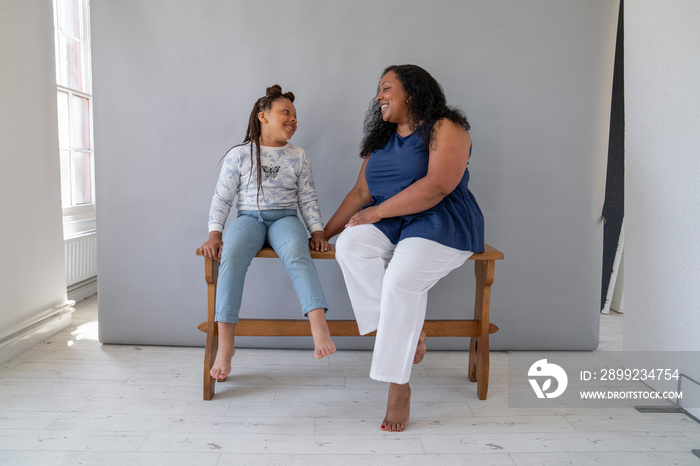 Smiling mother looking and daughter (6-7)