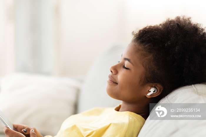 Black Teen Girl Listening Music Wearing Earbuds Relaxing At Home