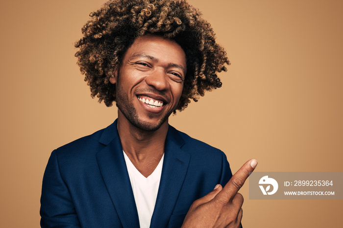 Cheerful black businessman pointing over shoulder