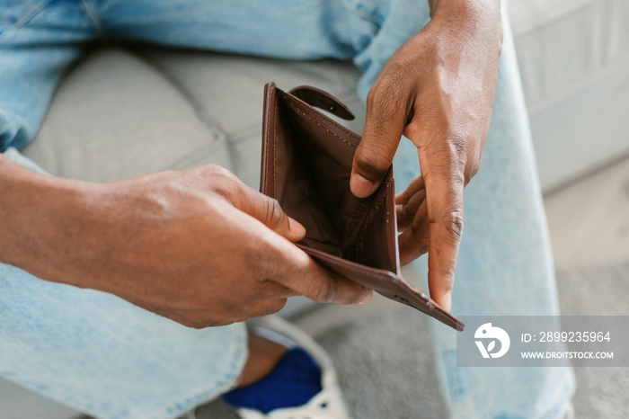 Financial crisis and bankruptcy concept. Unrecognizable black man showing empty wallet at camera