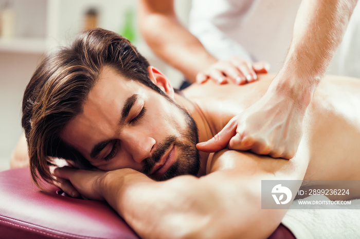 Young man is having massage on spa treatment.