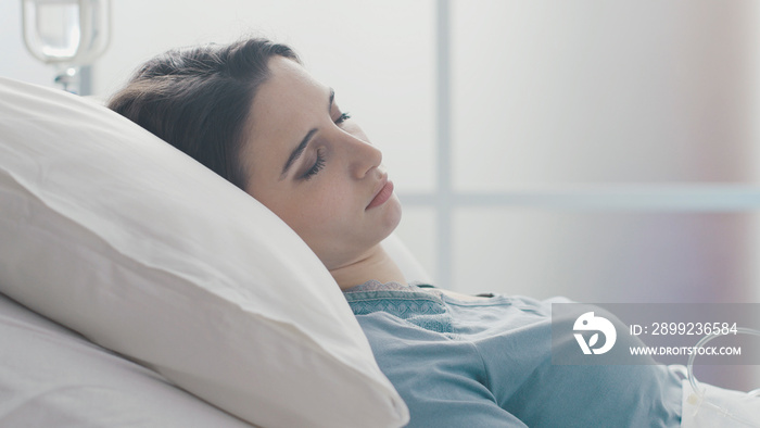 Young female patient lying in bed at the hospital