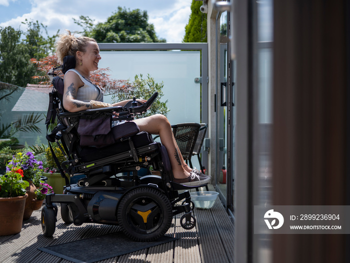 Woman in electric wheelchair relaxing on deck