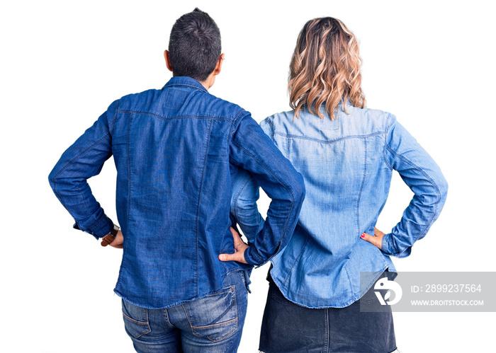 Couple of women wearing casual clothes standing backwards looking away with arms on body