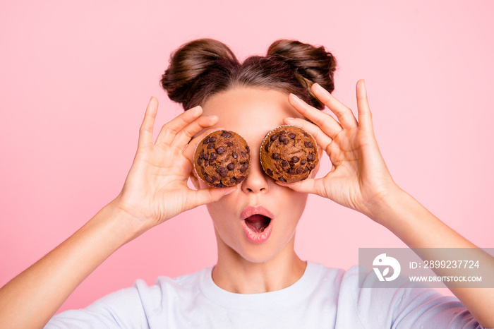 Close-up portrait of nice lovely cute attractive funky amazed girl holding in hands two cakes closing covering eyes like glasses opened mouth isolated over pink pastel background