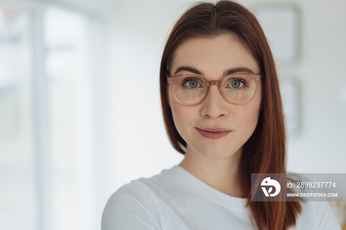 Pretty young woman with large grey eyes wearing glasses