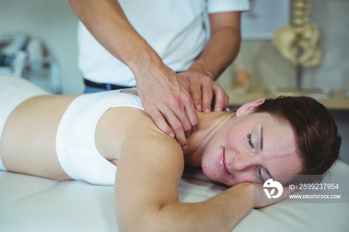 Physiotherapist giving neck massage to a woman