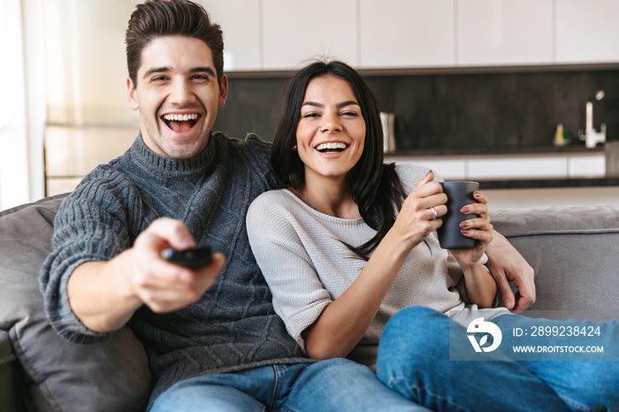 Happy young couple sitting on a couch at home