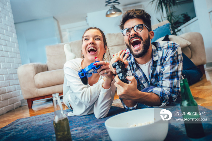 Cute couple playing video games at home