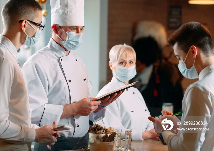 Cafe staff on morning briefing wearing protective masks.