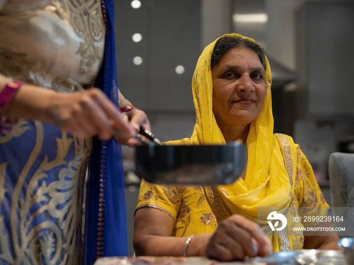 Family in traditional clothing eating meal at home