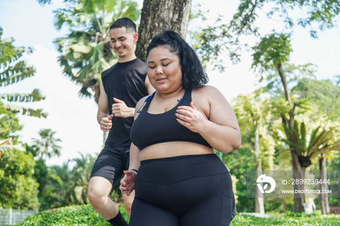 Two friends going on a run together in the park