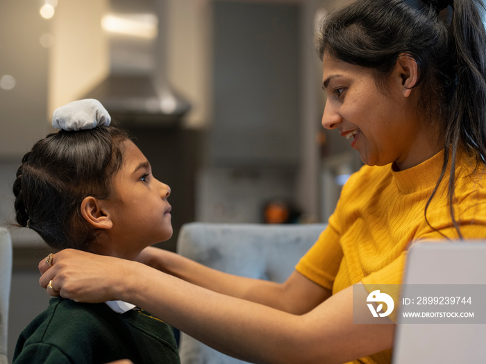 Mother helping son (6-7) get ready for school