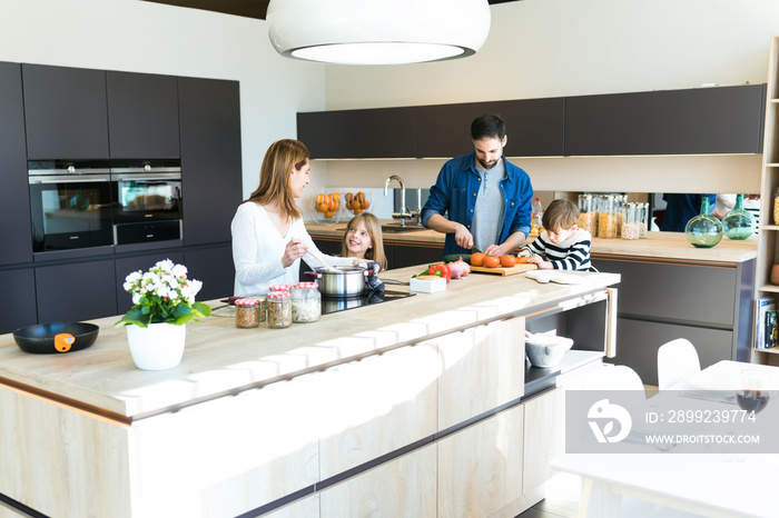 Beautiful cute family having fun while cooking together in the kitchen at home.