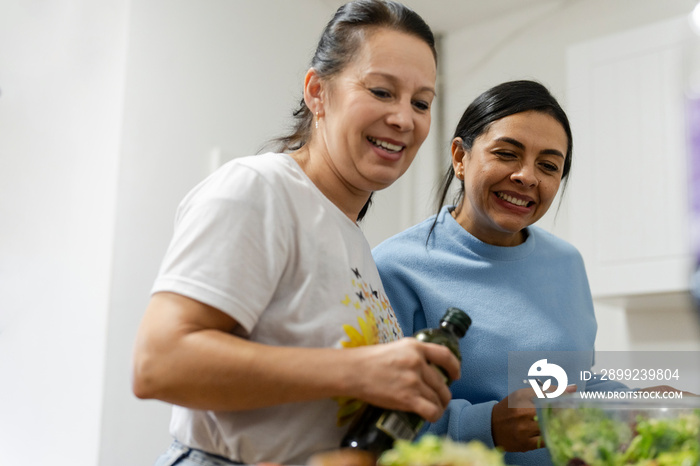 Two women preparing meal in kitchen