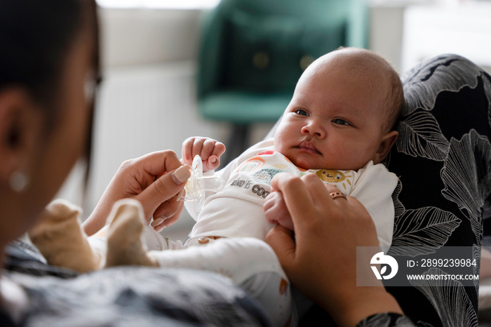 Portrait of newborn baby girl sitting on mother laps