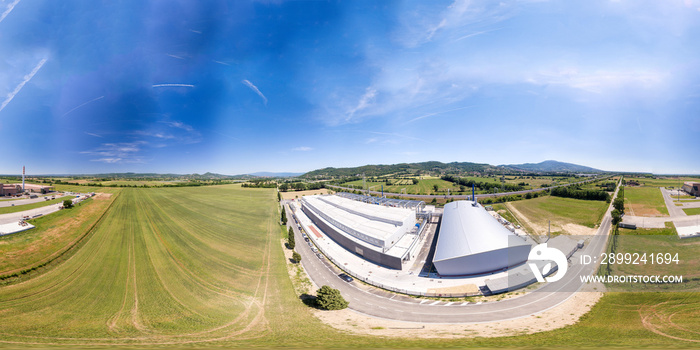 360 degrees image of industrial warehouse. Aerial view of meadows and buidlings on a beautiful sunny day