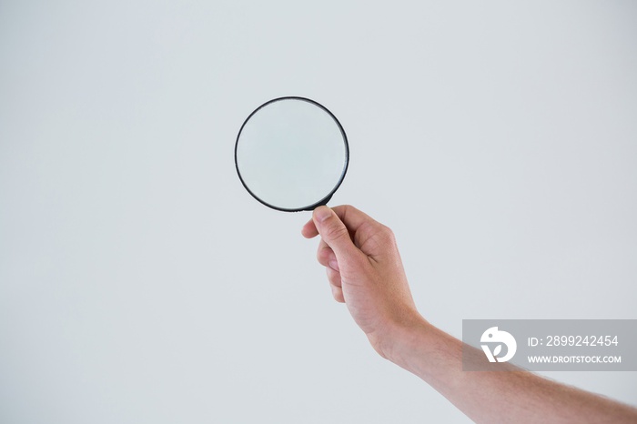 Hand holding magnifying glass