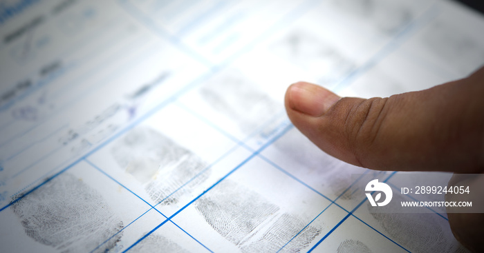 Close-up shots of criminal Taking finger to fingerprinting crime page file.Crime and violence concept.